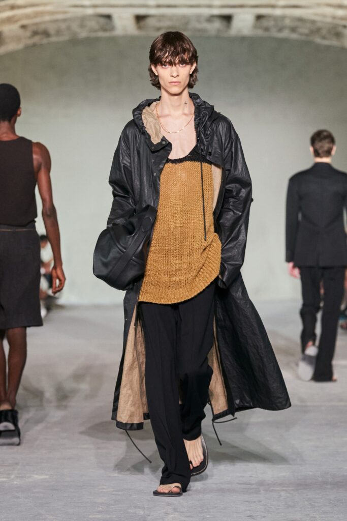 A relaxed black leather coat layered over a brown v-neck top.