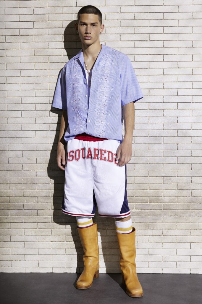 A blue buttoned short-sleeve shirt paired with white shorts featuring a bold logo.