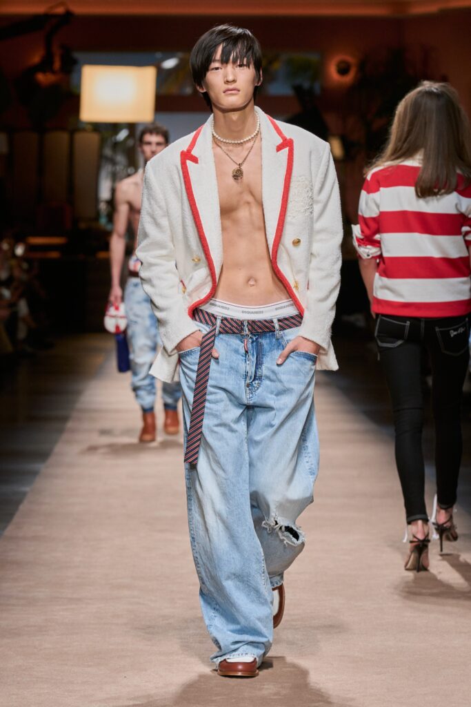 A relaxed fit white collared jacket paired with blue denim pants featuring a buttoned design.
