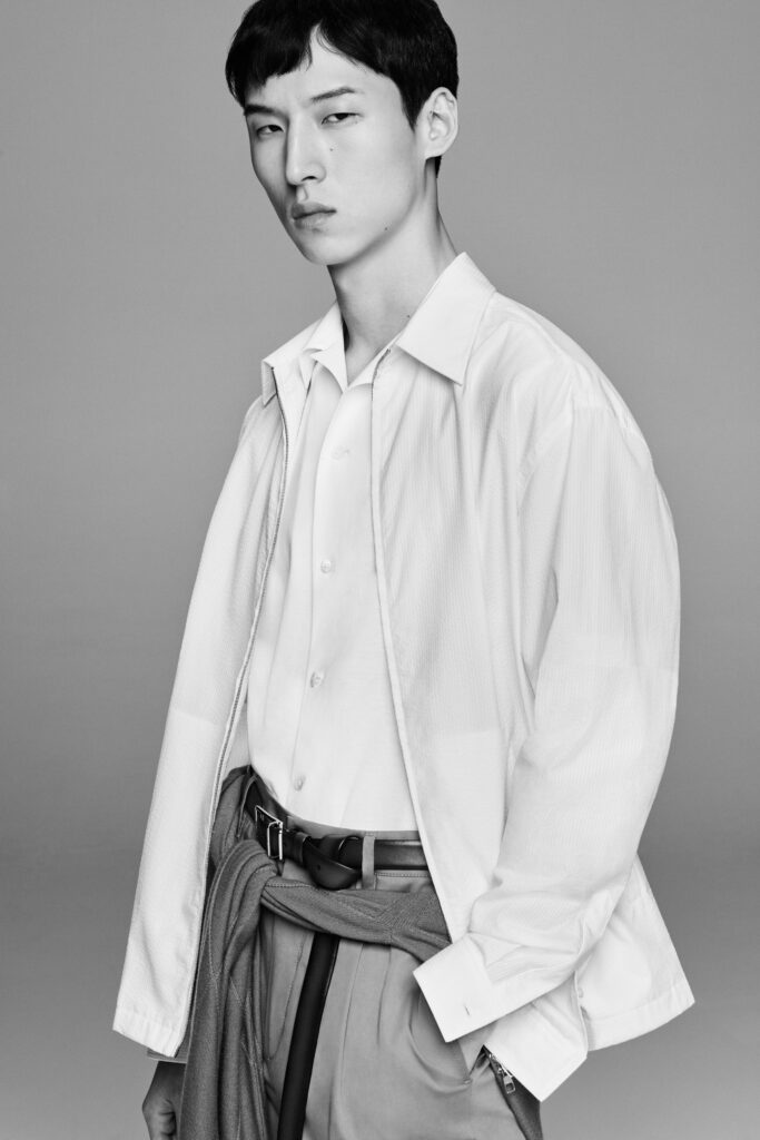 A relaxed white long-sleeve shirt jacket with a collared neckline and buttoned detail.