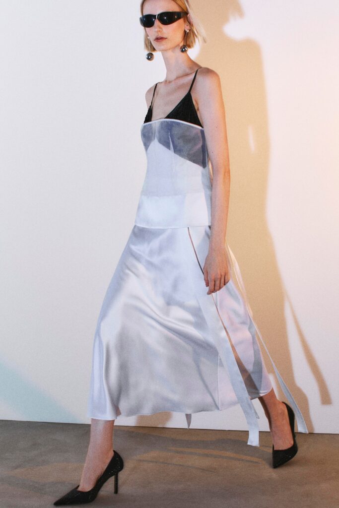 A fitted black and white silk dress with a sleeveless design and asymmetric details.