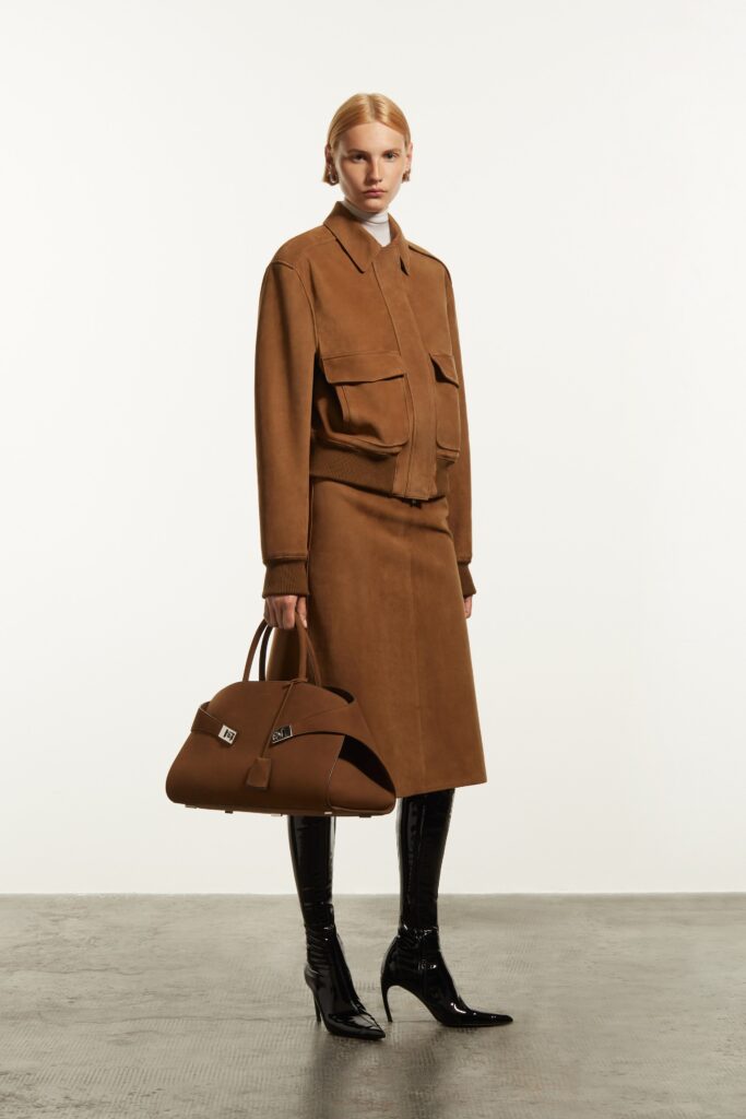 A fitted brown suede jacket with a collared neckline paired with a straight-leg skirt.