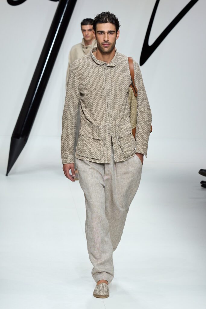 A relaxed beige cotton jacket with long sleeves and collared design, paired with matching pants.