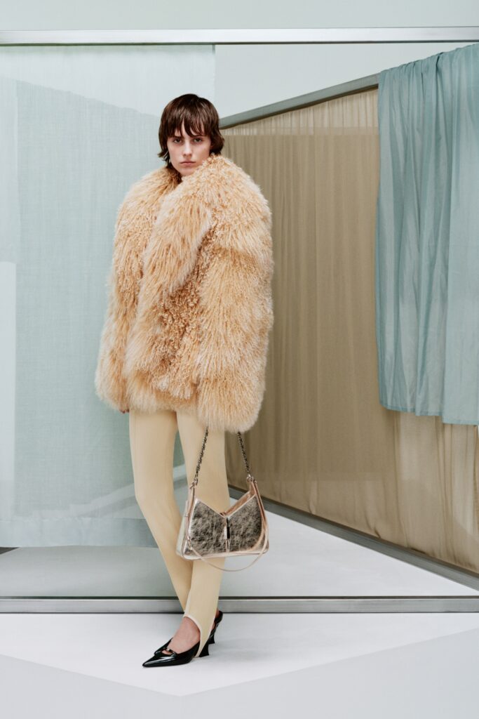 A fitted beige fur coat paired with sleek black leather pants for a chic look.