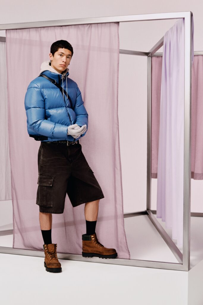 A relaxed blue jacket with long sleeves paired with high-waisted black shorts featuring pockets.