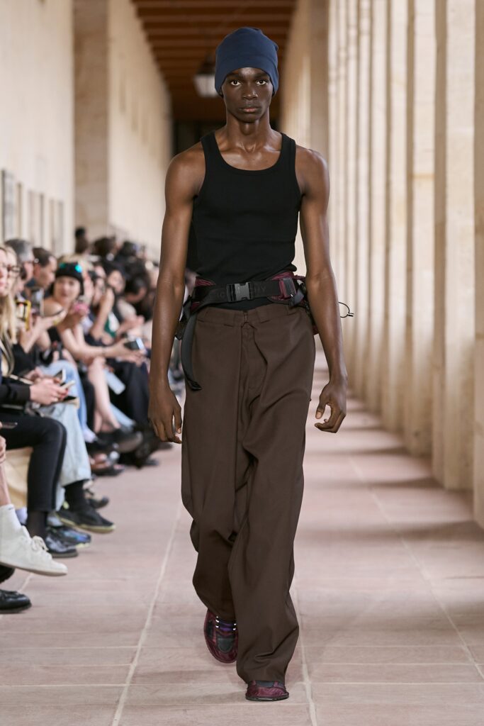 A relaxed black sleeveless tank-top paired with wide-leg brown pants.