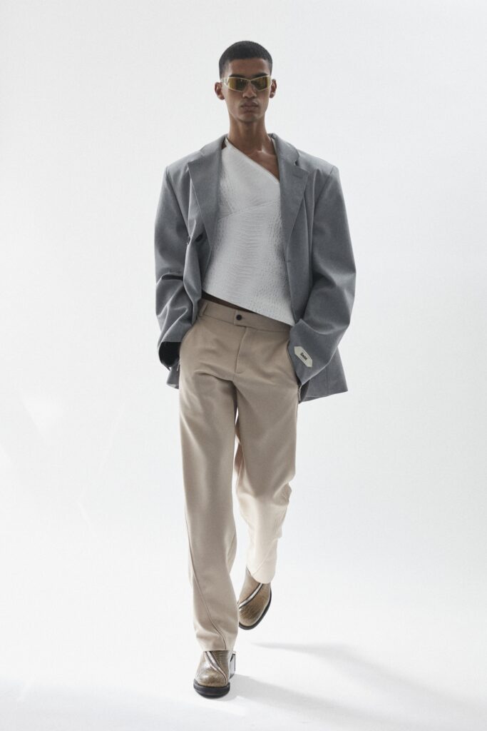 A relaxed gray jacket paired with beige pants, featuring a V-neckline and straight-leg fit.