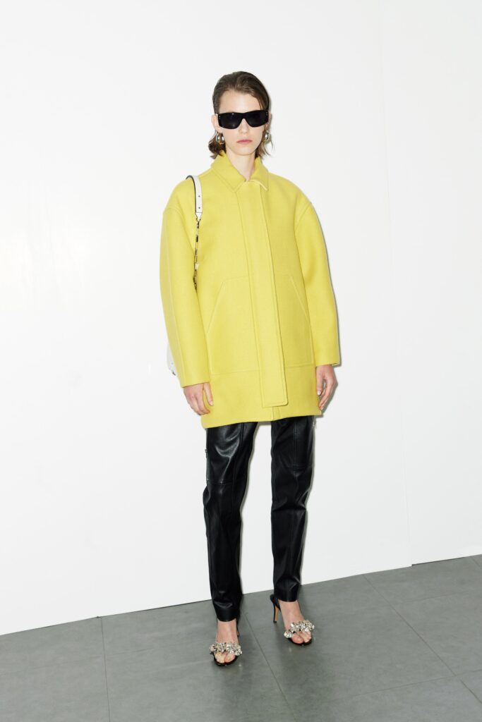 An oversized yellow wool coat paired with black leather straight-leg pants.