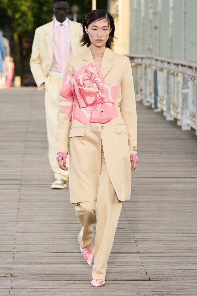 A tailored beige suit featuring a long-sleeve collared jacket with a pink floral print.