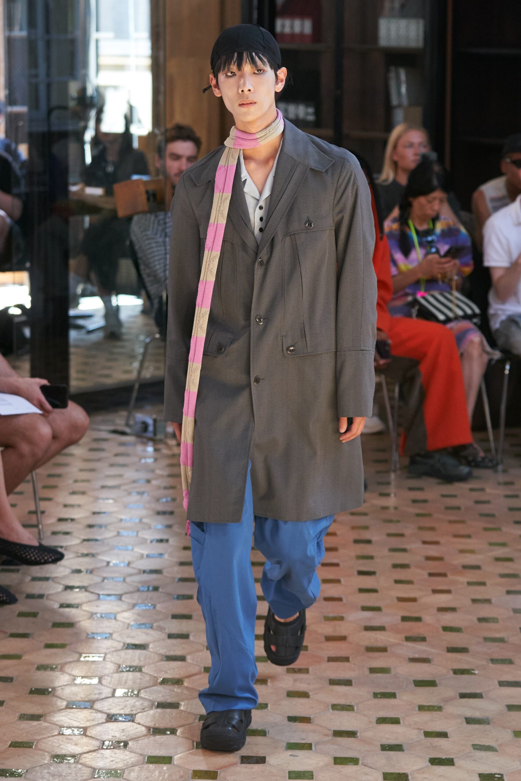 A relaxed gray cotton jacket with a collared neckline paired with blue straight-leg pants.
