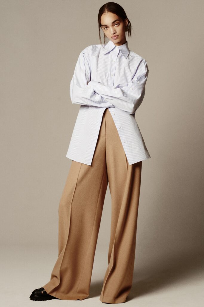 A relaxed white long-sleeve collared shirt paired with wide-leg beige pants.