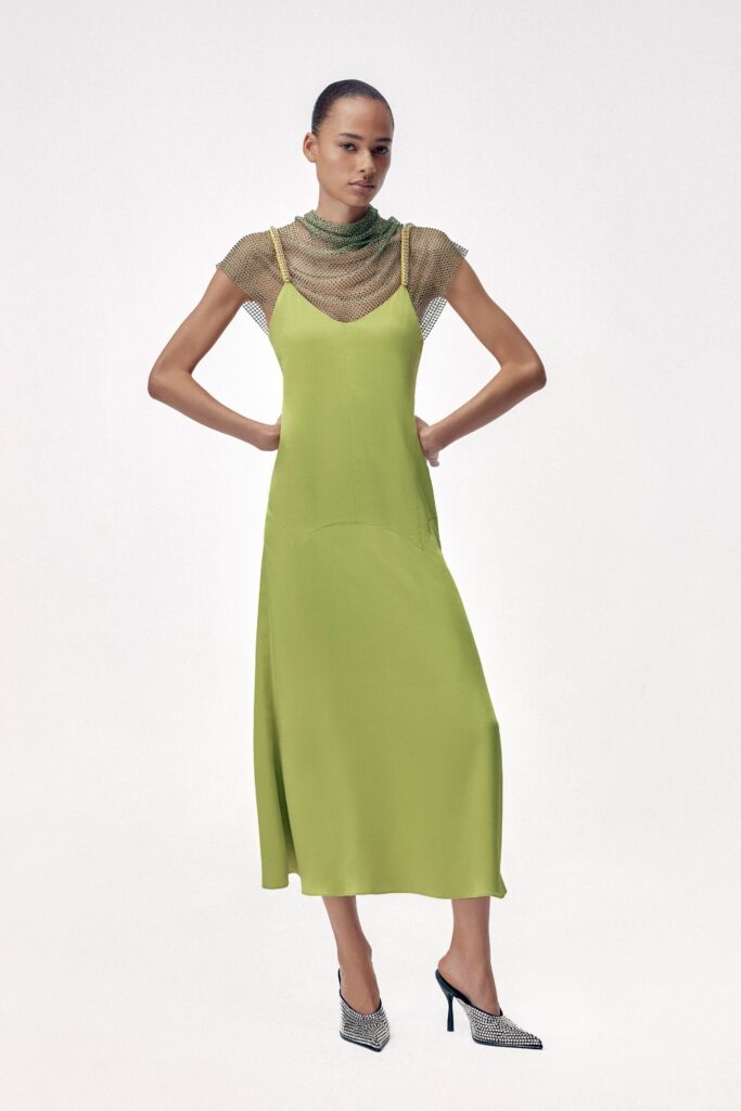 A relaxed green silk sleeveless dress with a V-neckline and asymmetric design.