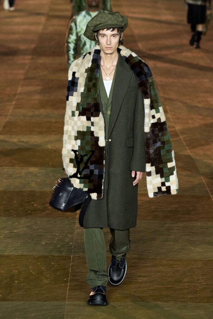A fitted green wool coat paired with pants, featuring a layered design and a collared neckline.
