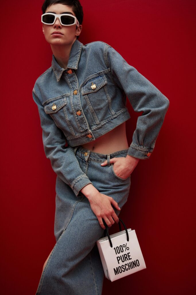 This fitted denim jacket features a classic collared design with buttoned closures, perfectly paired with a high-waisted denim skirt. The combination creates a cohesive look that emphasizes a streamlined silhouette, while the light blue hue offers a fresh take on casual style.
