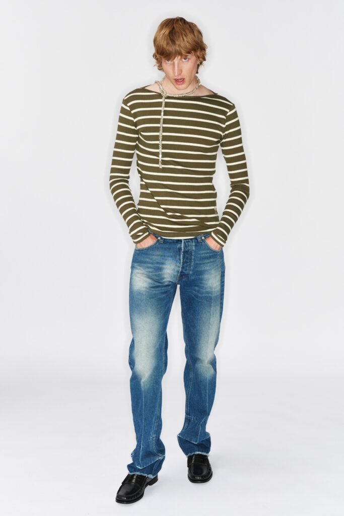 A fitted long-sleeve striped green shirt paired with straight-leg blue jeans.