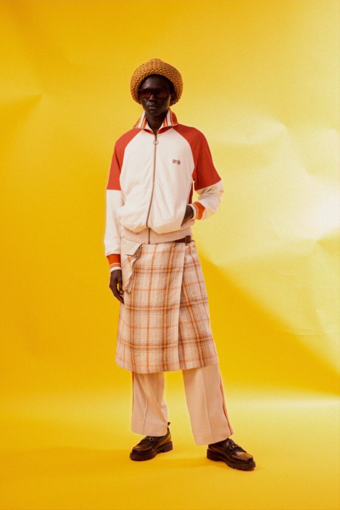 A relaxed fit white jacket with long sleeves and a collared design, paired with a checked skirt.