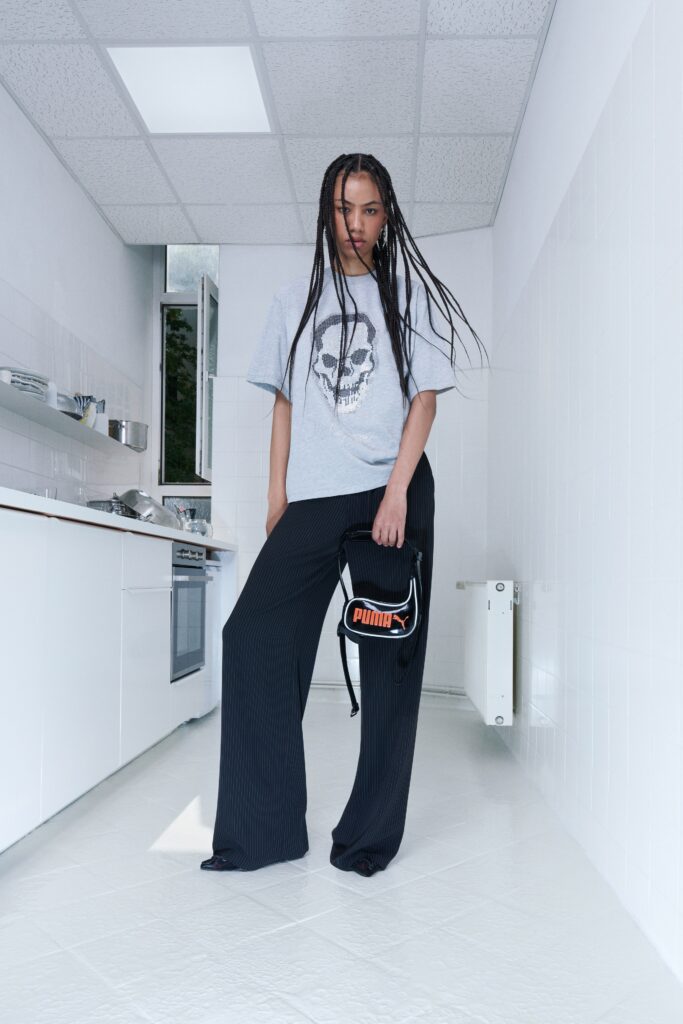 A relaxed gray printed top paired with high-waisted black wide-leg pants.