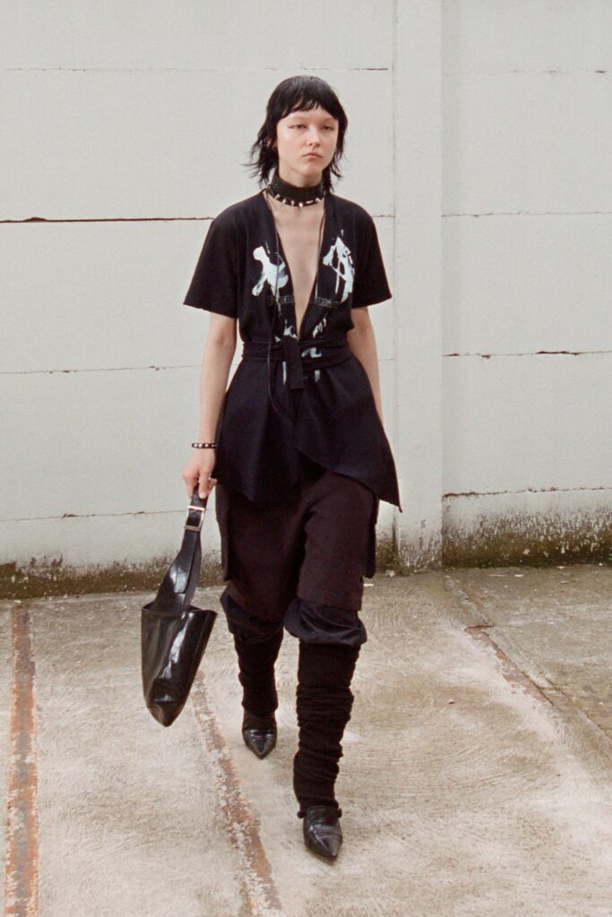 A fitted black dress with a short-sleeve top and asymmetric design detail.