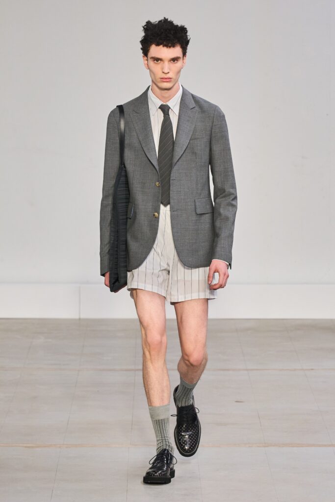 A fitted gray blazer paired with white striped shorts, featuring a collared shirt underneath.