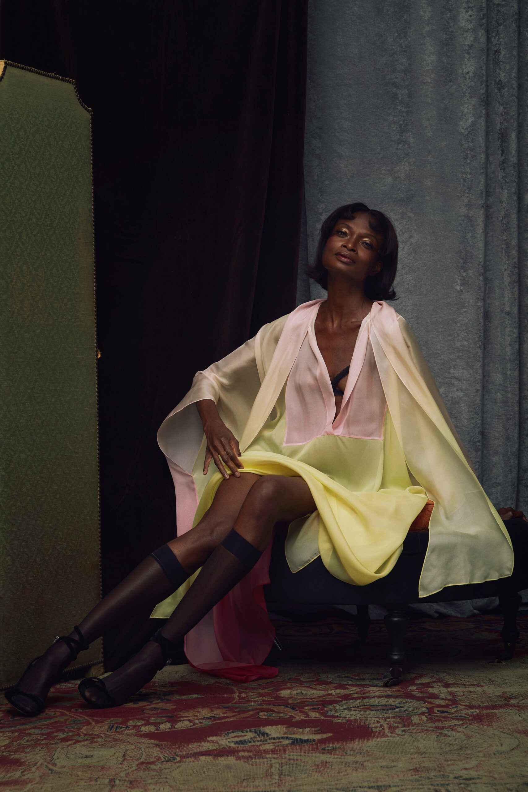 A relaxed pink and yellow silk dress with a V-neckline and layered cape detail.