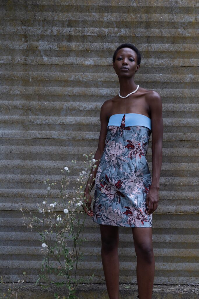 A fitted floral silk strapless dress featuring a vibrant blue and multicolor design.
