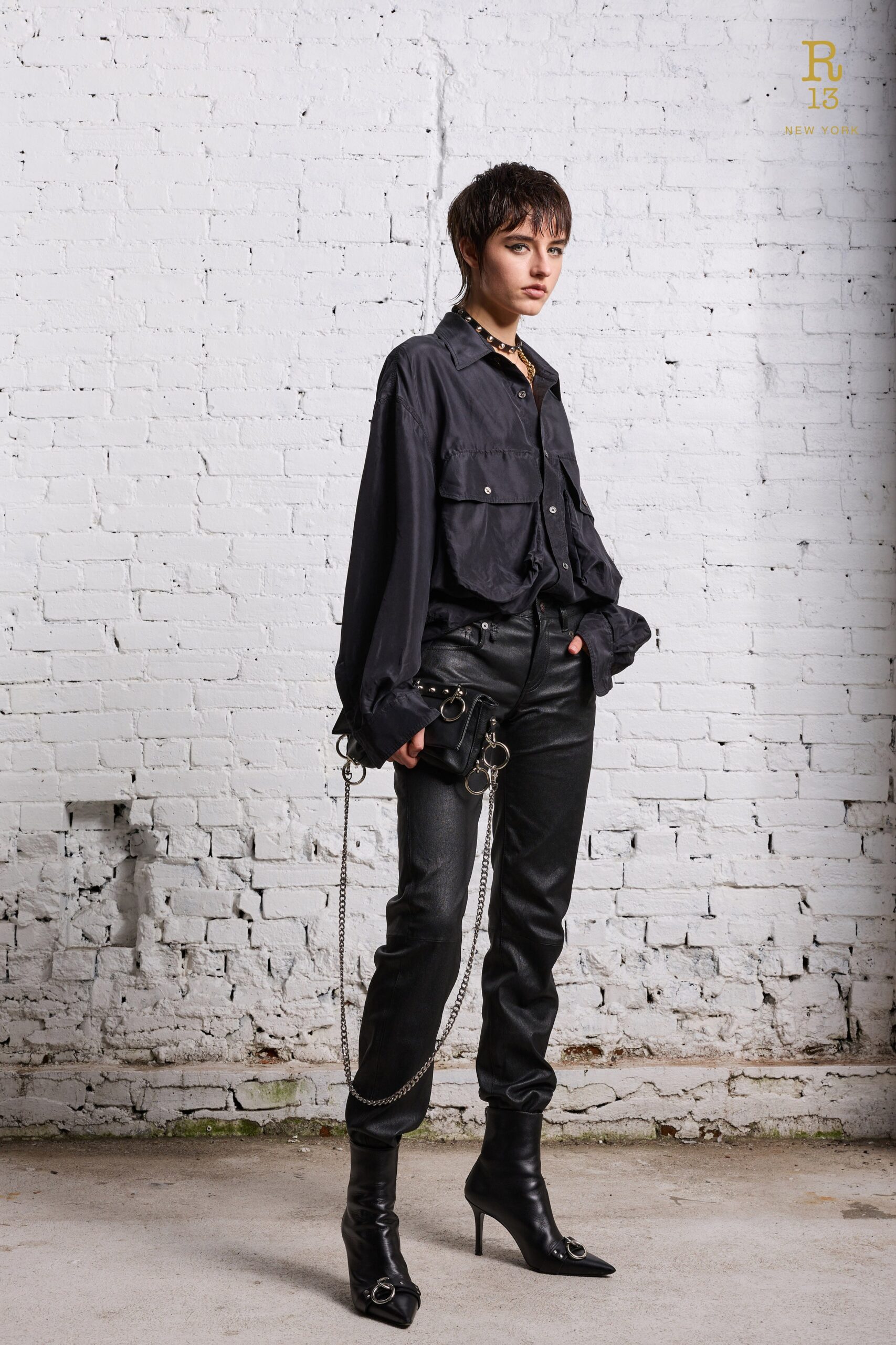 A fitted black long-sleeve collared shirt paired with straight-leg black pants.