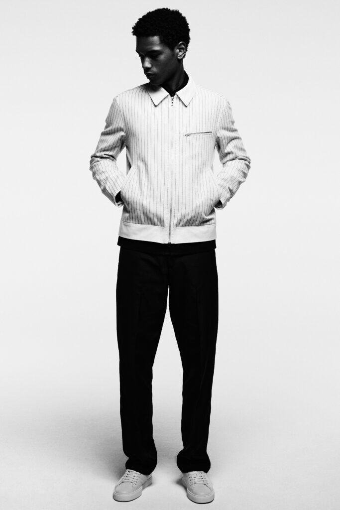 A fitted black and white striped jacket paired with black pants for a sleek look.