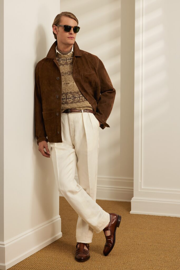 A relaxed brown suede jacket with a collared neckline paired with straight-leg white pants.