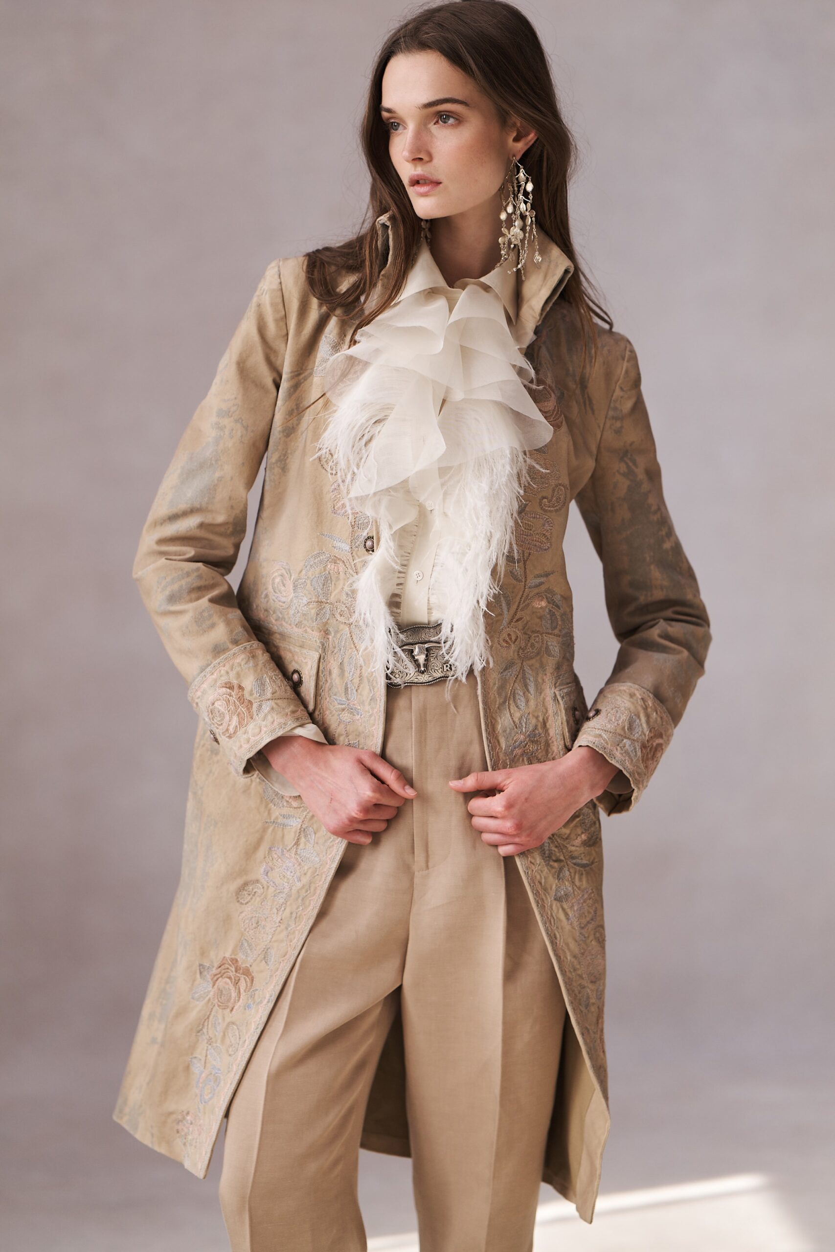 A relaxed beige embroidered coat paired with pleated pants for a sophisticated look.