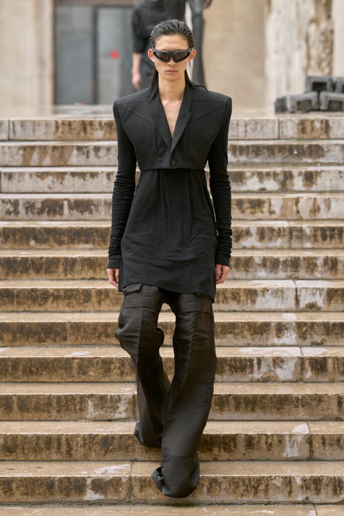 A fitted black dress with long sleeves and a collared neckline, paired with matching pants.