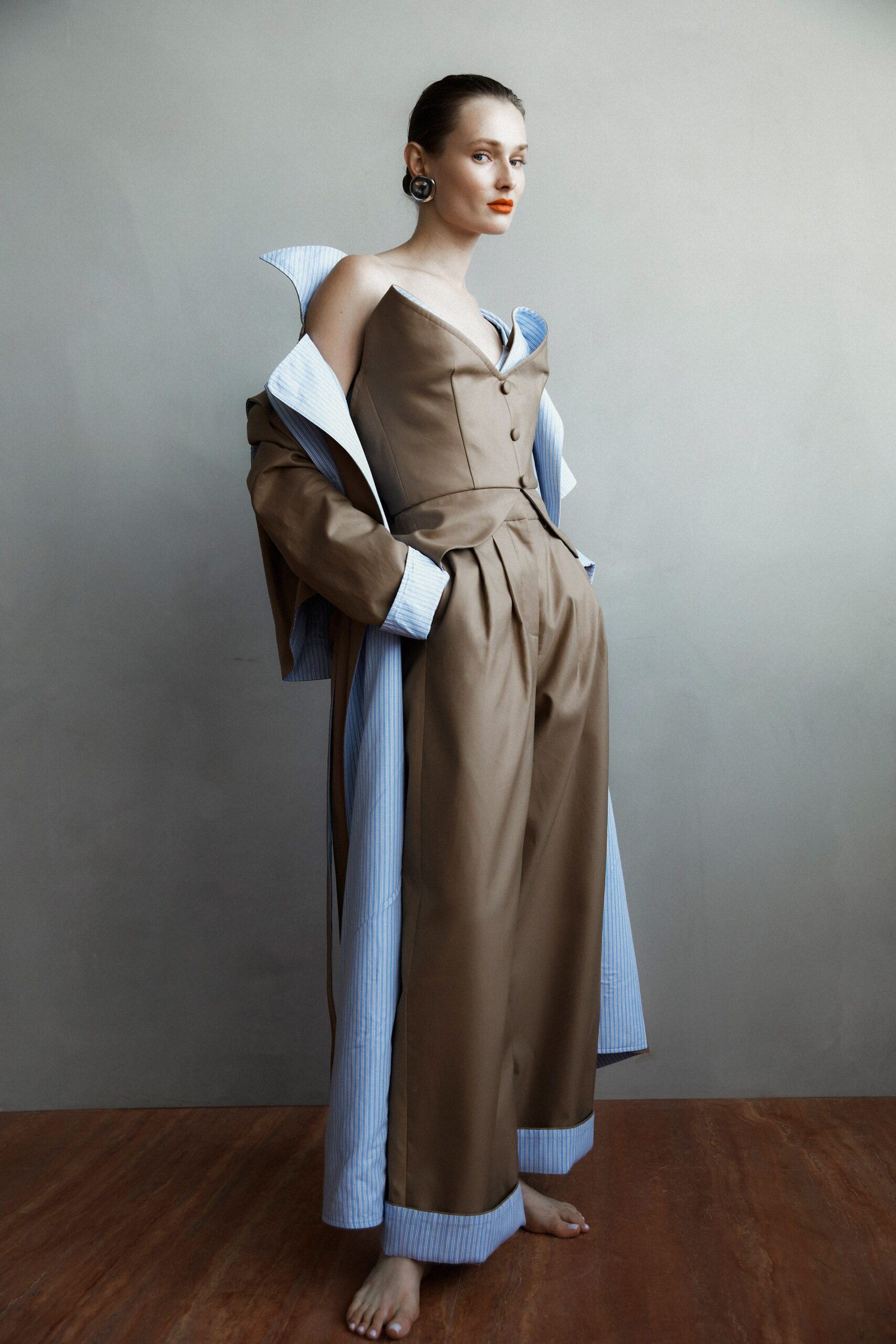 A relaxed brown cotton jacket with a collared design paired with wide-leg pants.