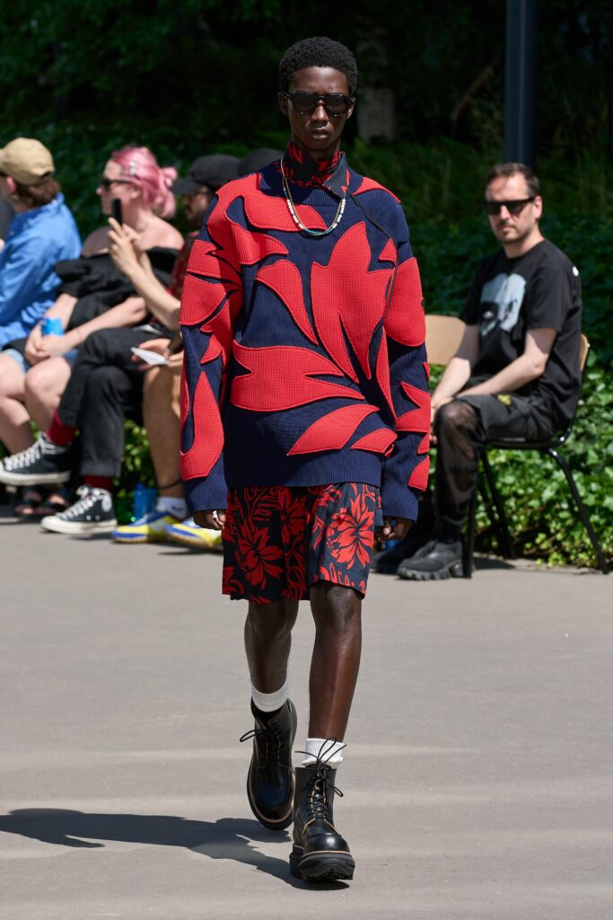 A relaxed fit red and blue printed sweater paired with floral shorts.