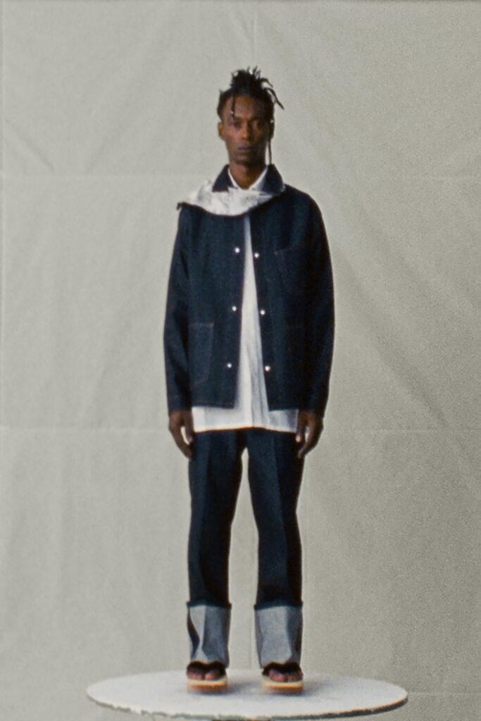 A relaxed blue denim jacket paired with white cotton pants featuring a collared design.