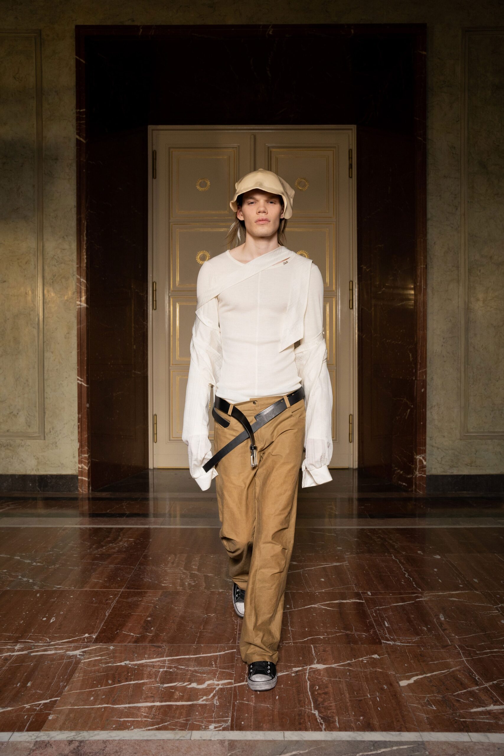 A relaxed white long-sleeve shirt with a collar paired with beige pants.