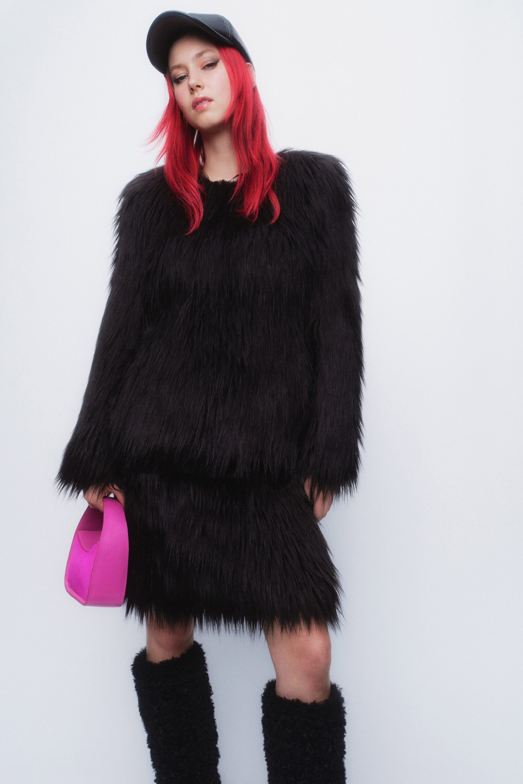 A relaxed black fur dress with long sleeves and a crew neckline, featuring a layered design.