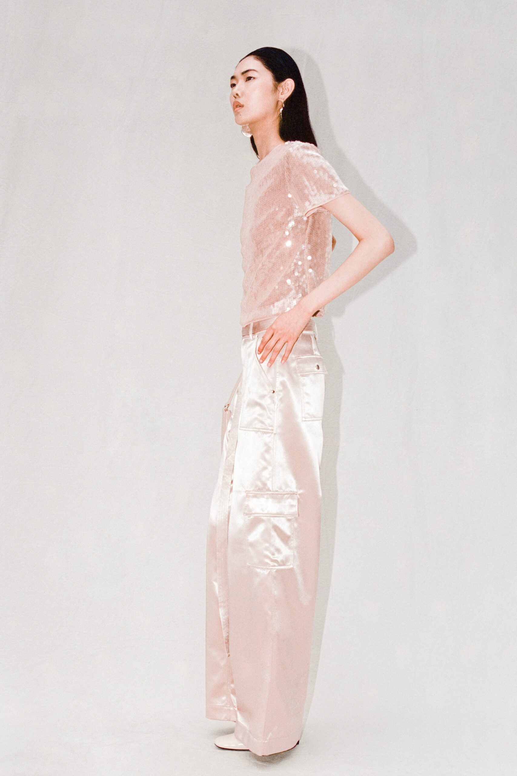 A relaxed pink silk top with sequins paired with wide-leg silk pants.