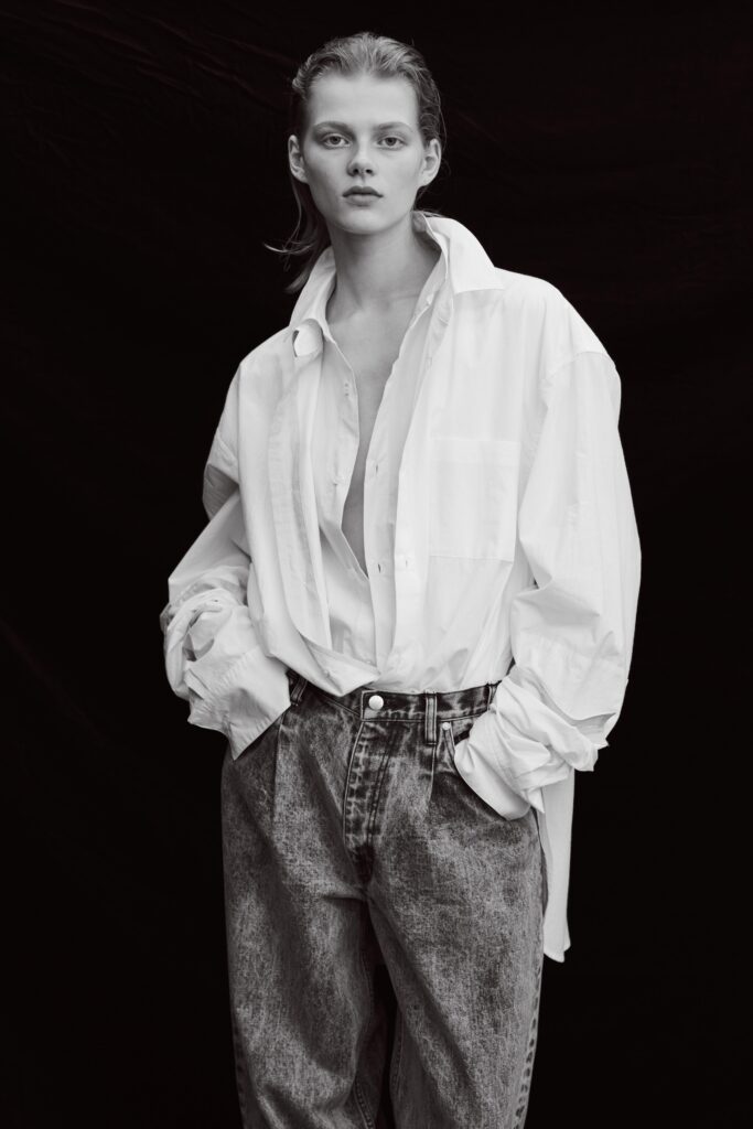 An oversized white buttoned shirt paired with high-waisted gray denim pants for a chic look.