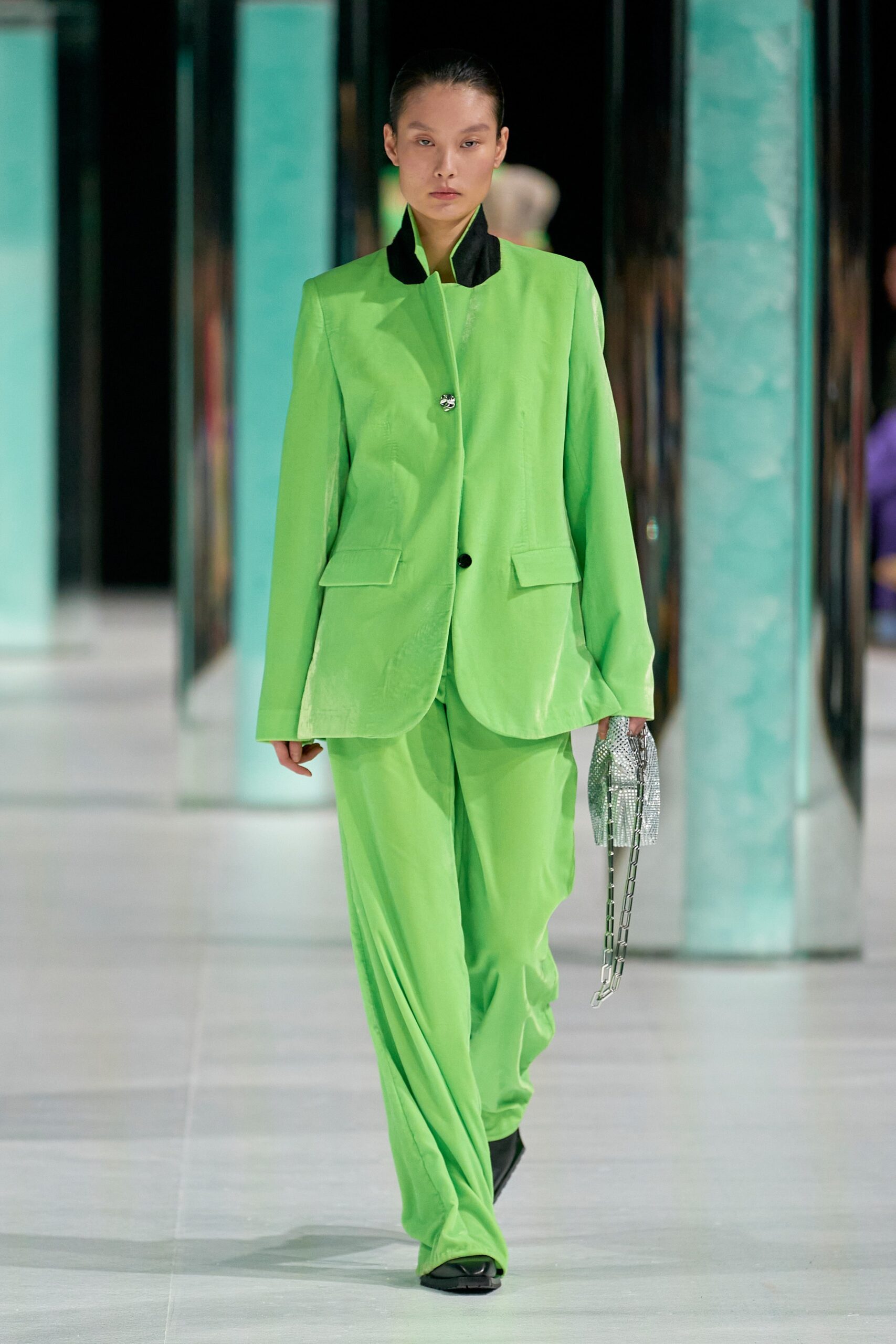 A relaxed green suit with long sleeves, a collared neckline, and wide-leg trousers.