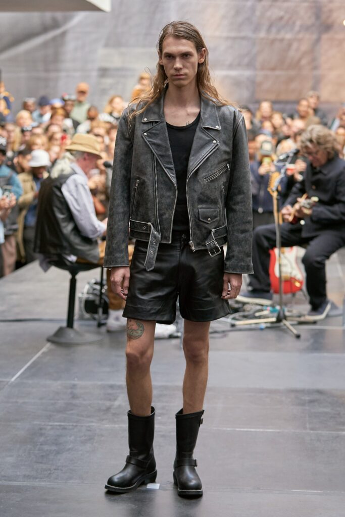 A fitted black leather jacket paired with matching fitted shorts, featuring a zippered detail.