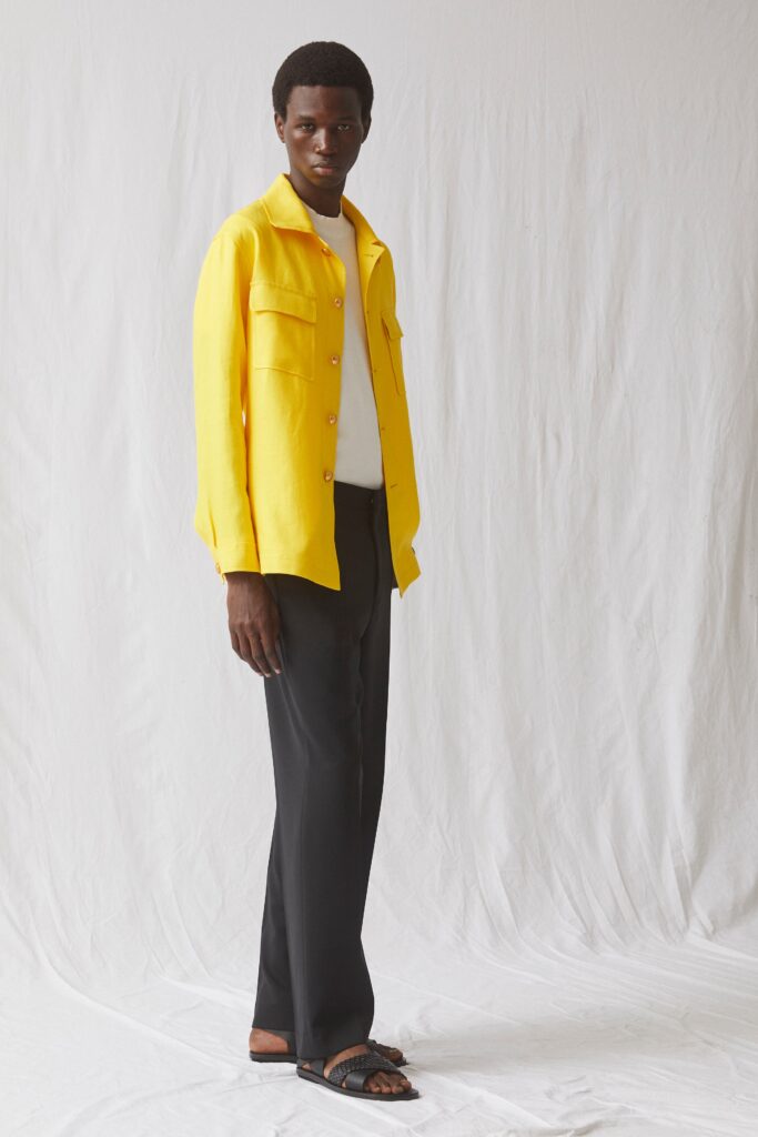A fitted yellow long-sleeve collared shirt paired with black straight-leg pants.
