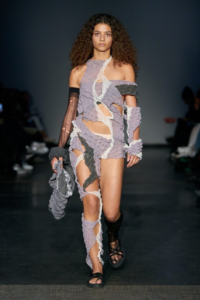A fitted gray cotton dress with a sleeveless cutout design and asymmetric details.