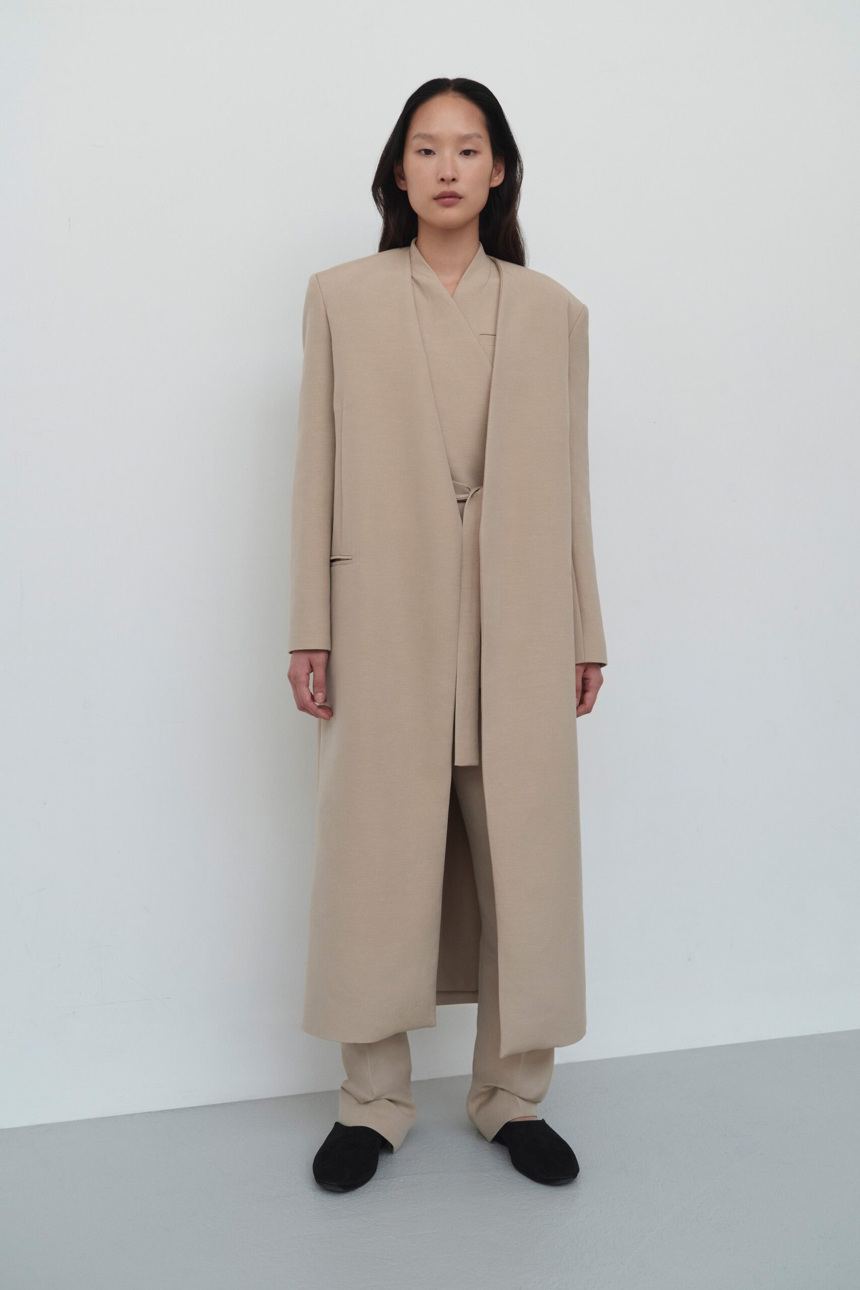 A relaxed beige cotton coat with long sleeves and straight-leg pants.