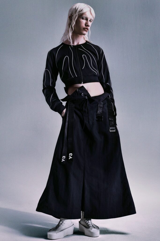 A fitted black cropped top with long sleeves paired with a wide-leg black skirt.