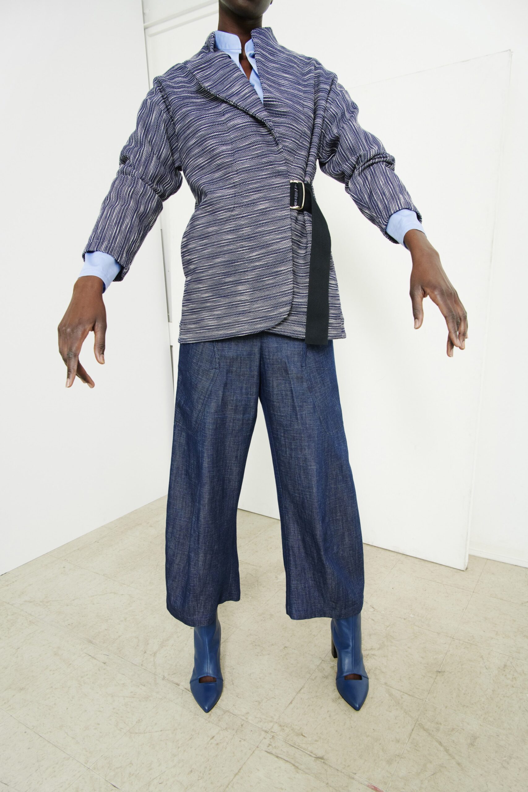 A relaxed blue denim jacket with long sleeves and a collared design paired with wide-leg pants.