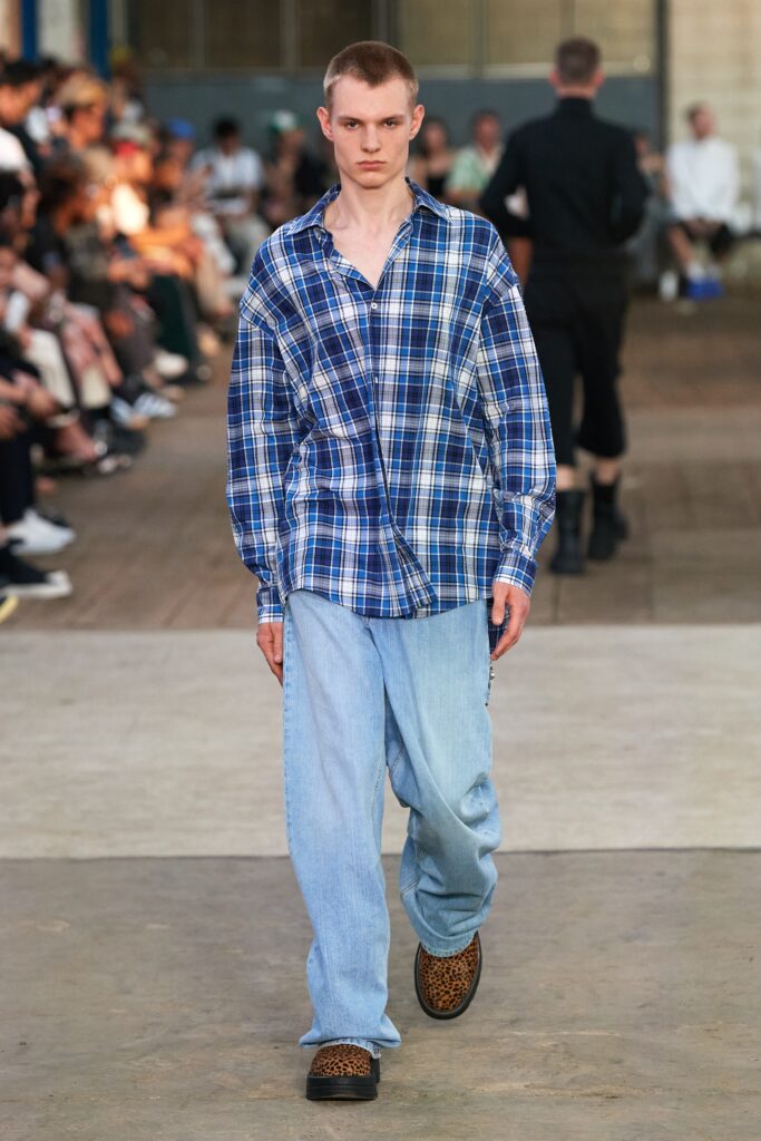 A relaxed blue checked shirt paired with wide-leg denim pants for a casual look.