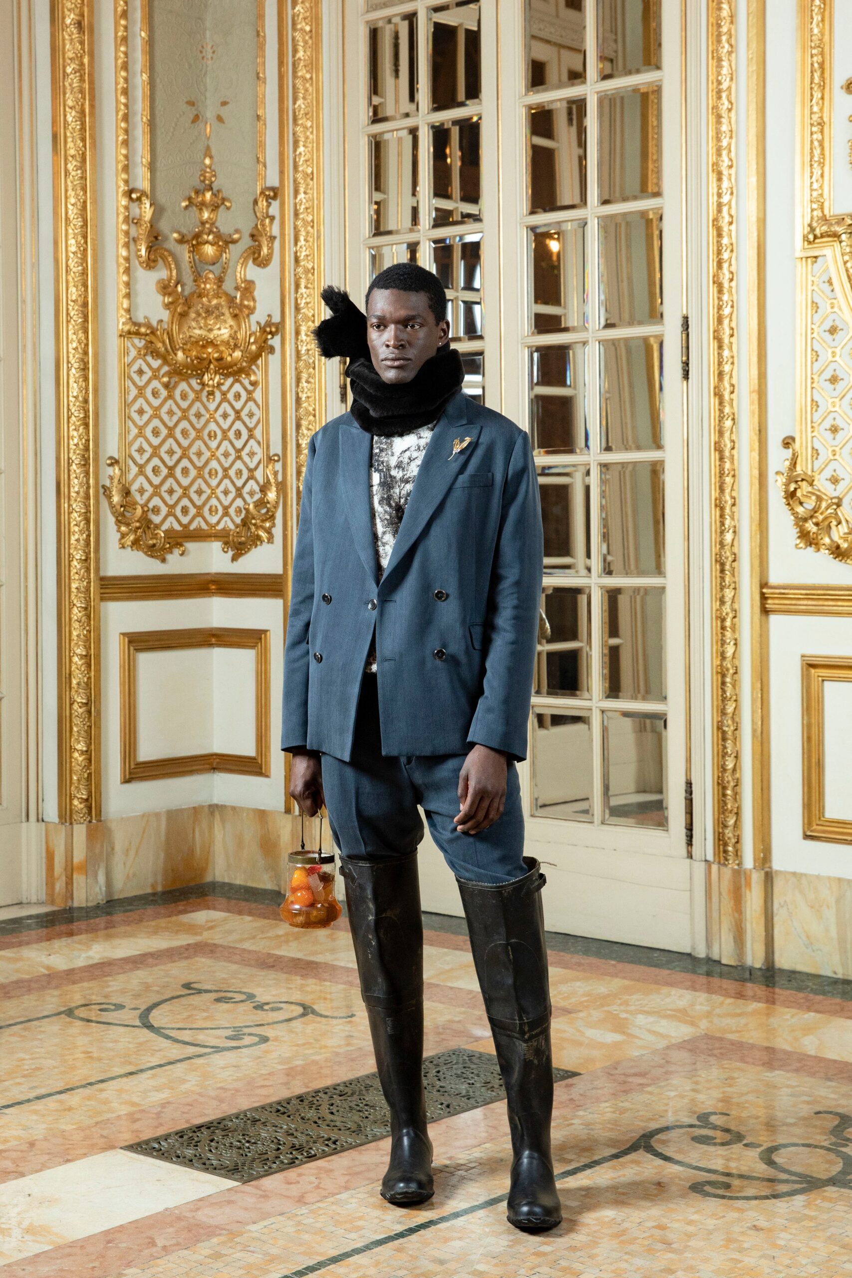 A fitted blue cotton jacket with long sleeves and a collared design, paired with black leather pants.