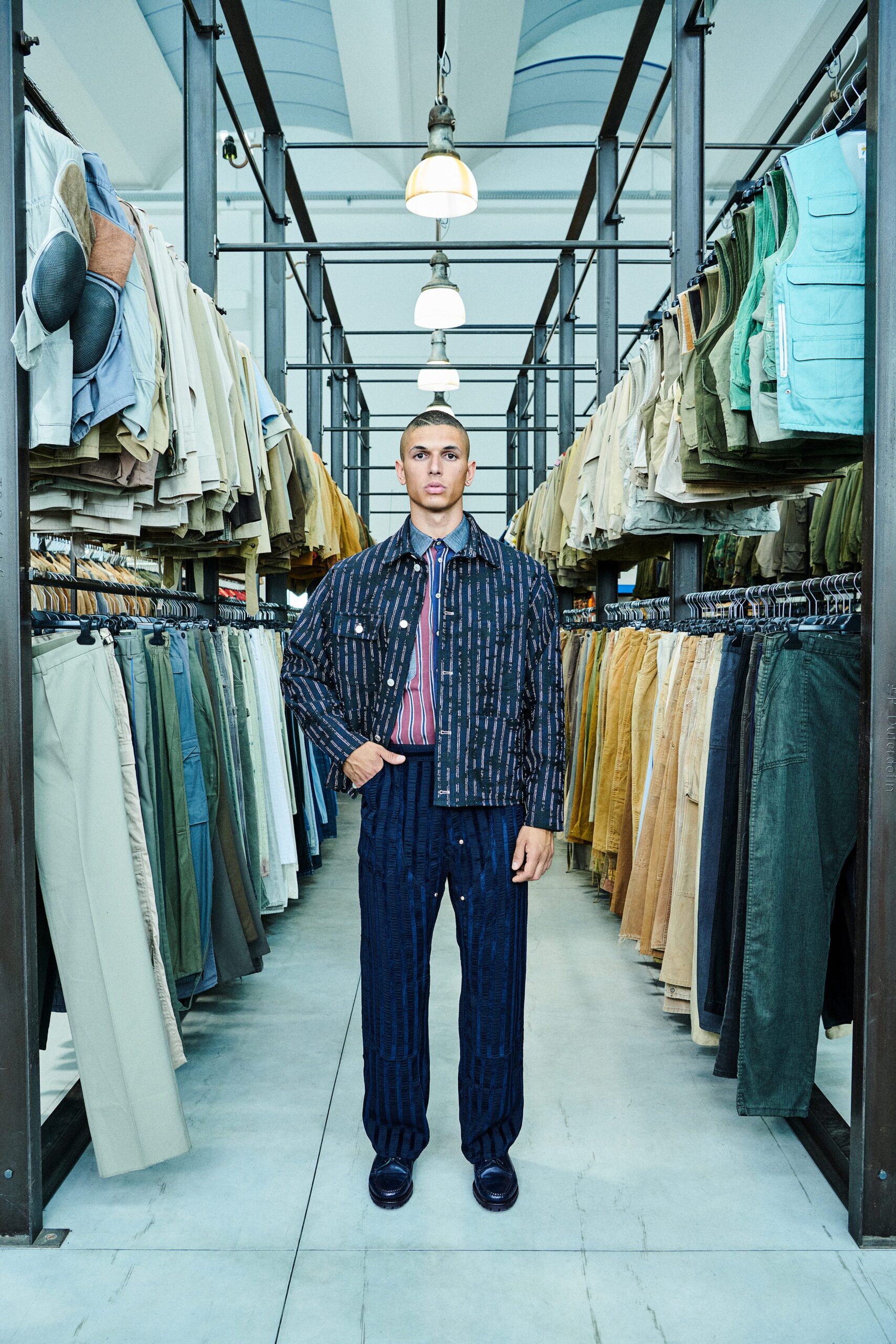 A relaxed-fit blue denim jacket with long sleeves and collared neck paired with striped pants.