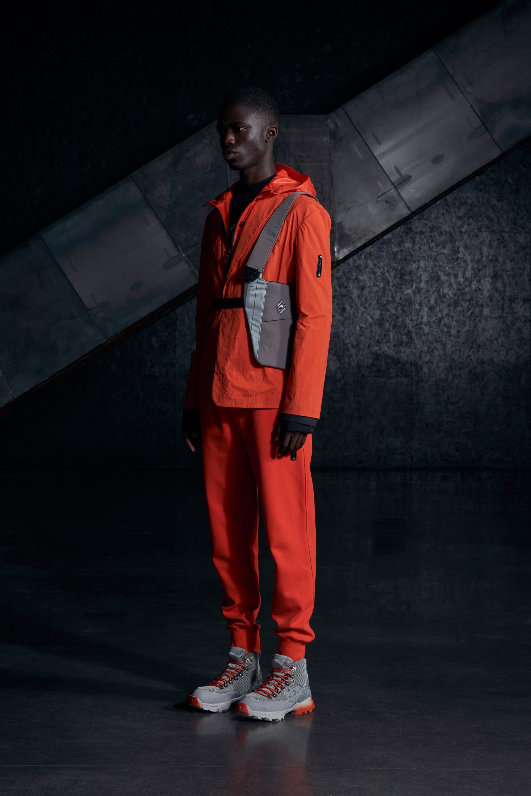 A relaxed fit orange hooded jacket paired with matching pants featuring zippered details.