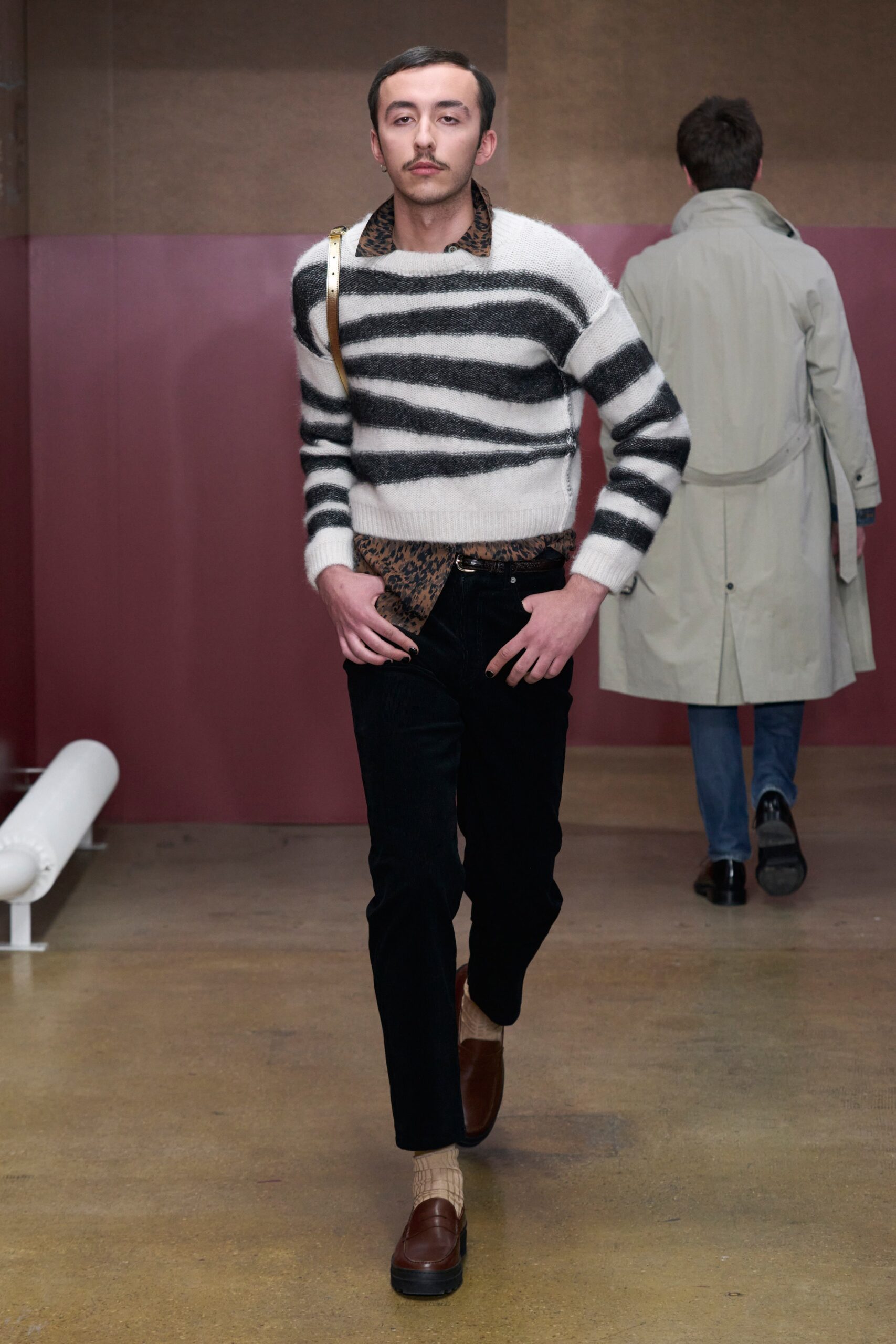 A fitted black and white striped wool sweater paired with slim black denim pants.