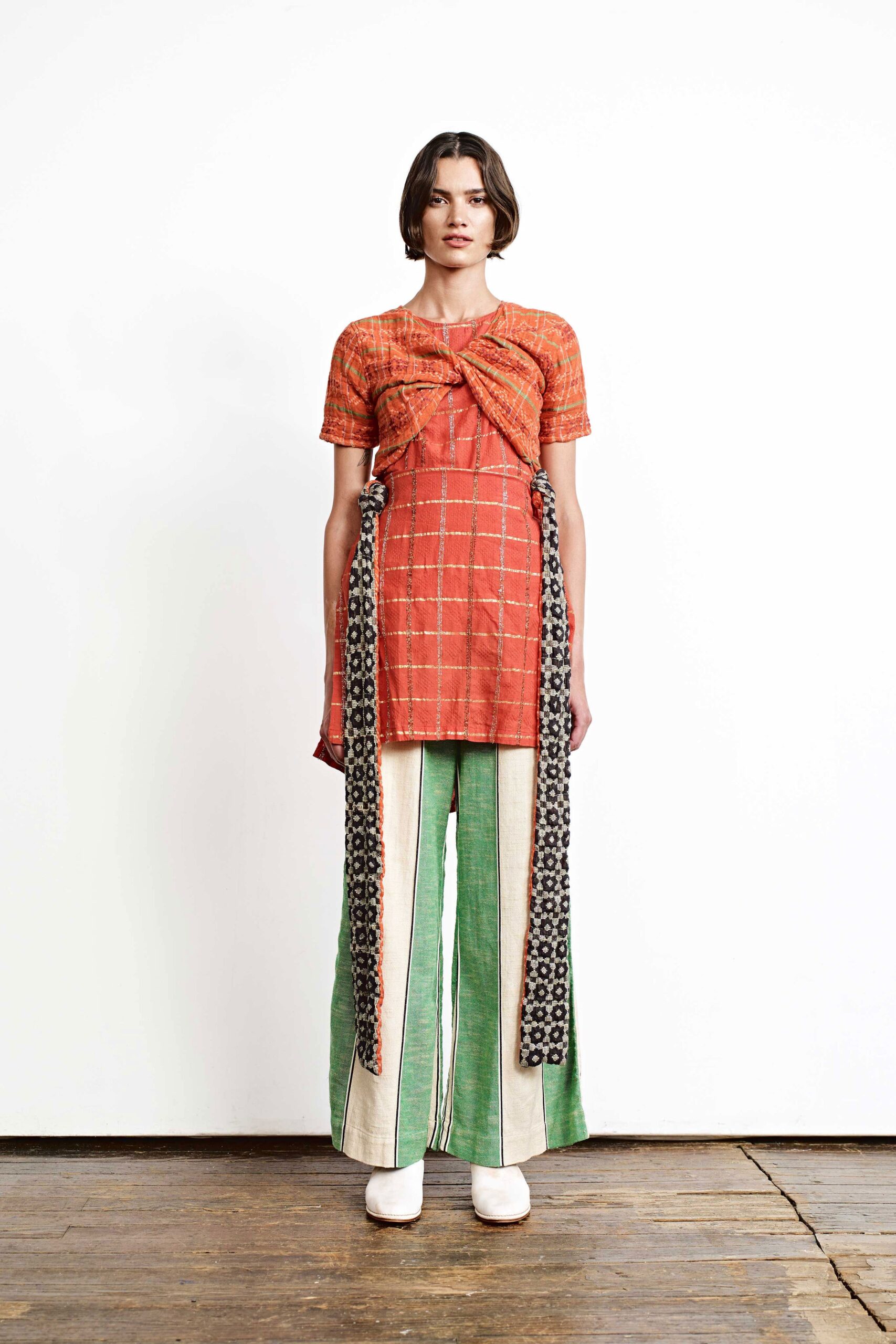 orange pleated top with wide-leg pants